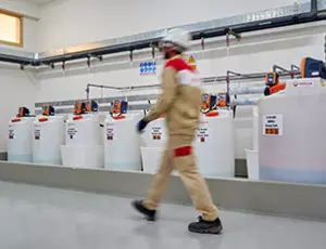 Man walking near Hydrex Chemicals cans