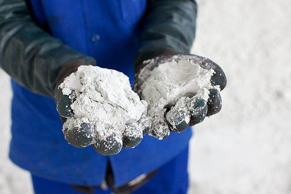 Hands wearing black gloves and showing paper pulp